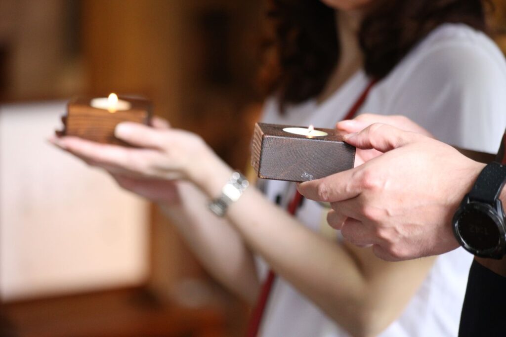 공익법인, 지정기부금단체 신청 요건 및 절차 Close-up of hands holding wooden candle holders during a serene ceremony.