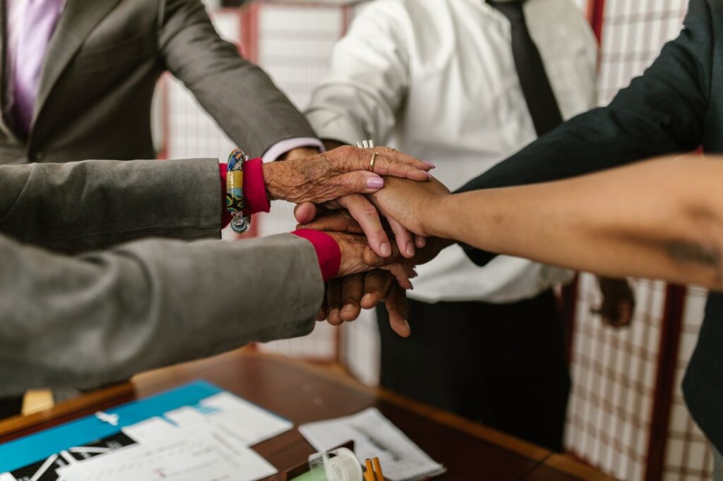 A diverse group of businesspeople uniting their hands symbolizing teamwork and cooperation.